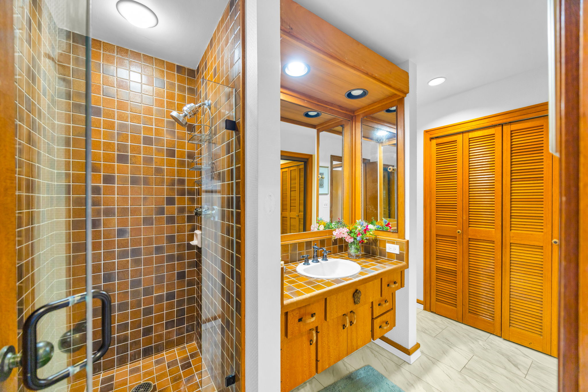 Guest bath with walk-in shower and stylish wood cabinetry.