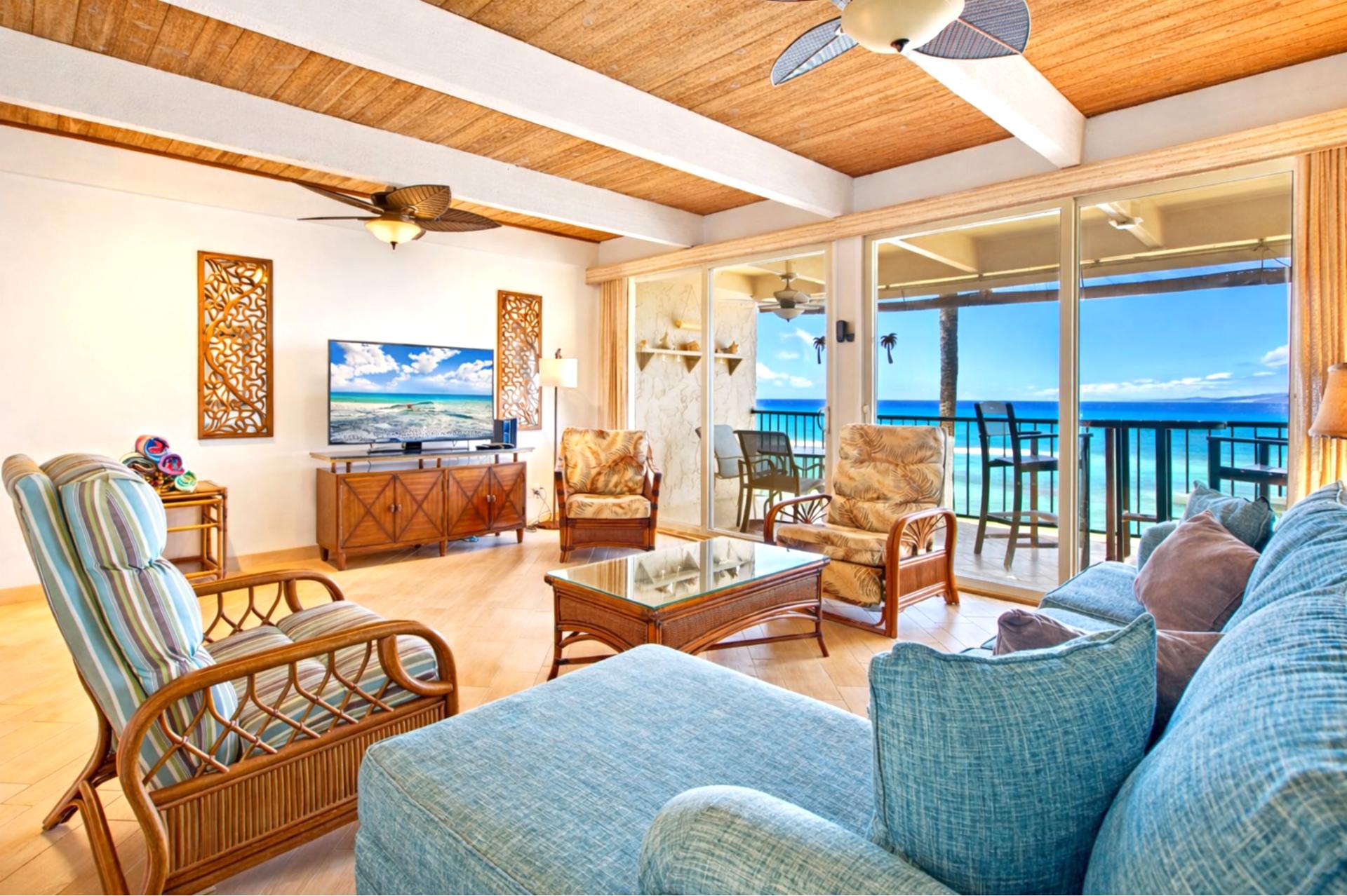 Gather on plush seating beneath exposed beams, with wide sliding doors framing uninterrupted views of the Pacific.