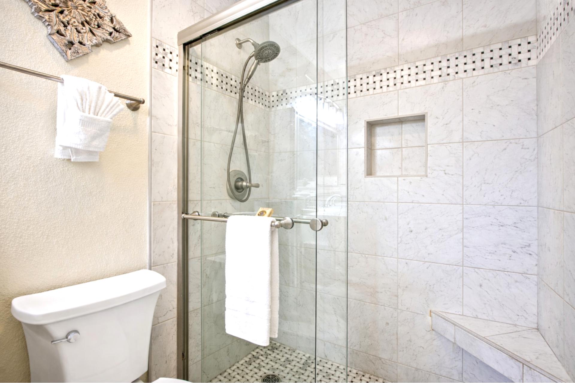 Step into your tiled walk in shower, complete with glass enclosure and built in niche for convenience and complimentary luxury L'Occitane bath amenities.