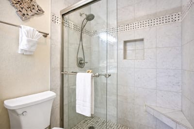 Step into your tiled walk in shower, complete with glass enclosure and built in niche for convenience and complimentary luxury L'Occitane bath amenities.