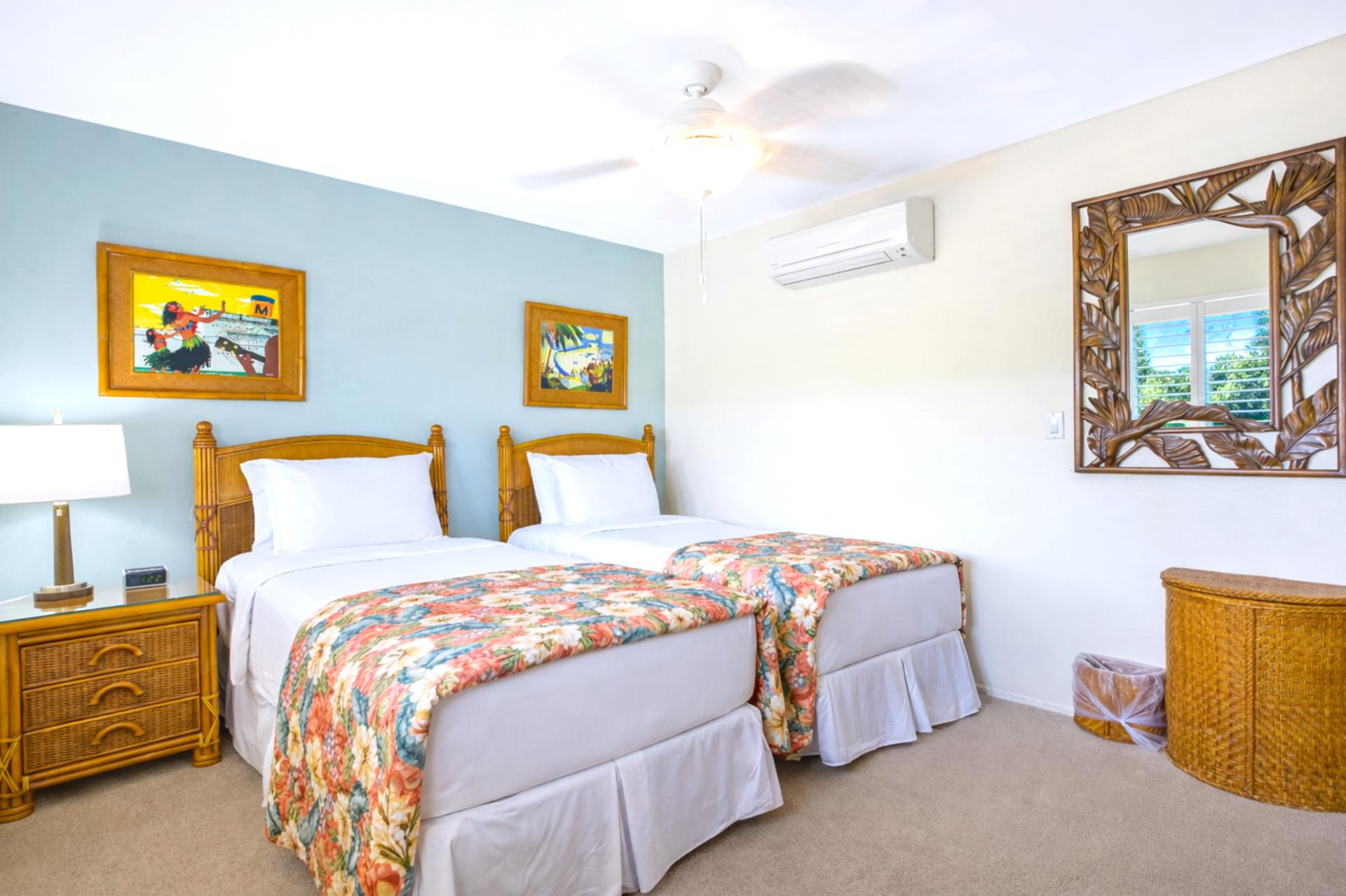 This bedroom offers two twin beds and bright island artwork, providing flexible comfort for family or friends.