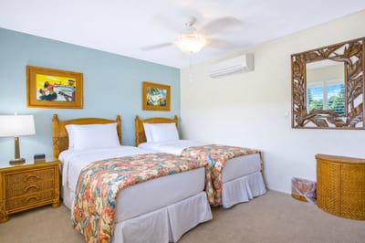 This bedroom offers two twin beds and bright island artwork, providing flexible comfort for family or friends.