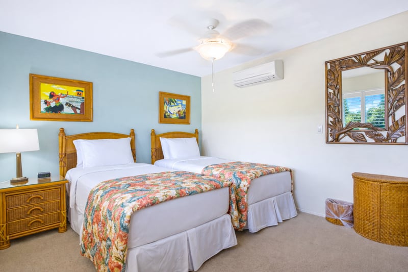 This bedroom offers two twin beds and bright island artwork, providing flexible comfort for family or friends.