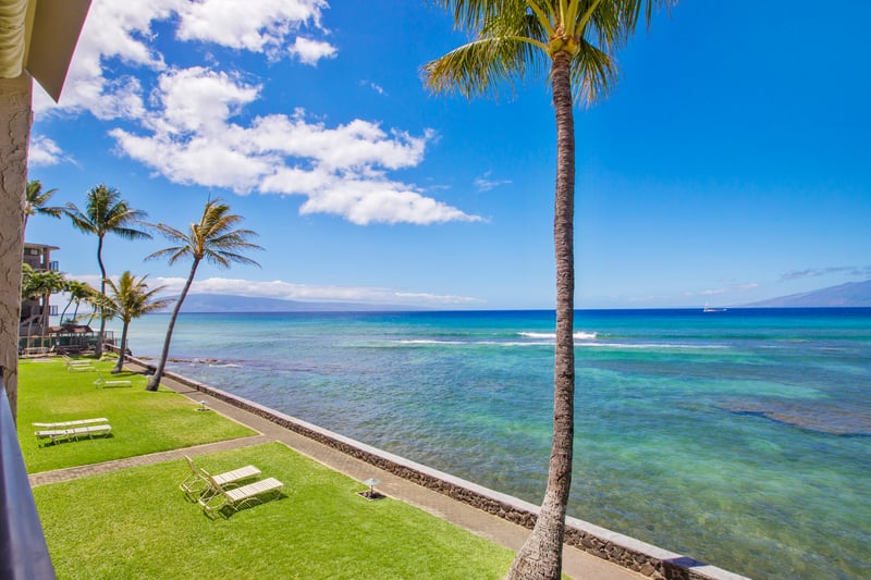 Just beyond your lawn, golden sand meets calm blue water, offering an easy beach day moments from your door.