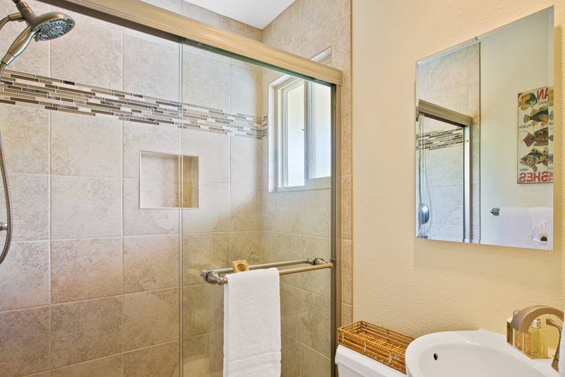 Enjoy a tiled walk in shower with glass doors and updated finishes, offering a fresh start to your day.
