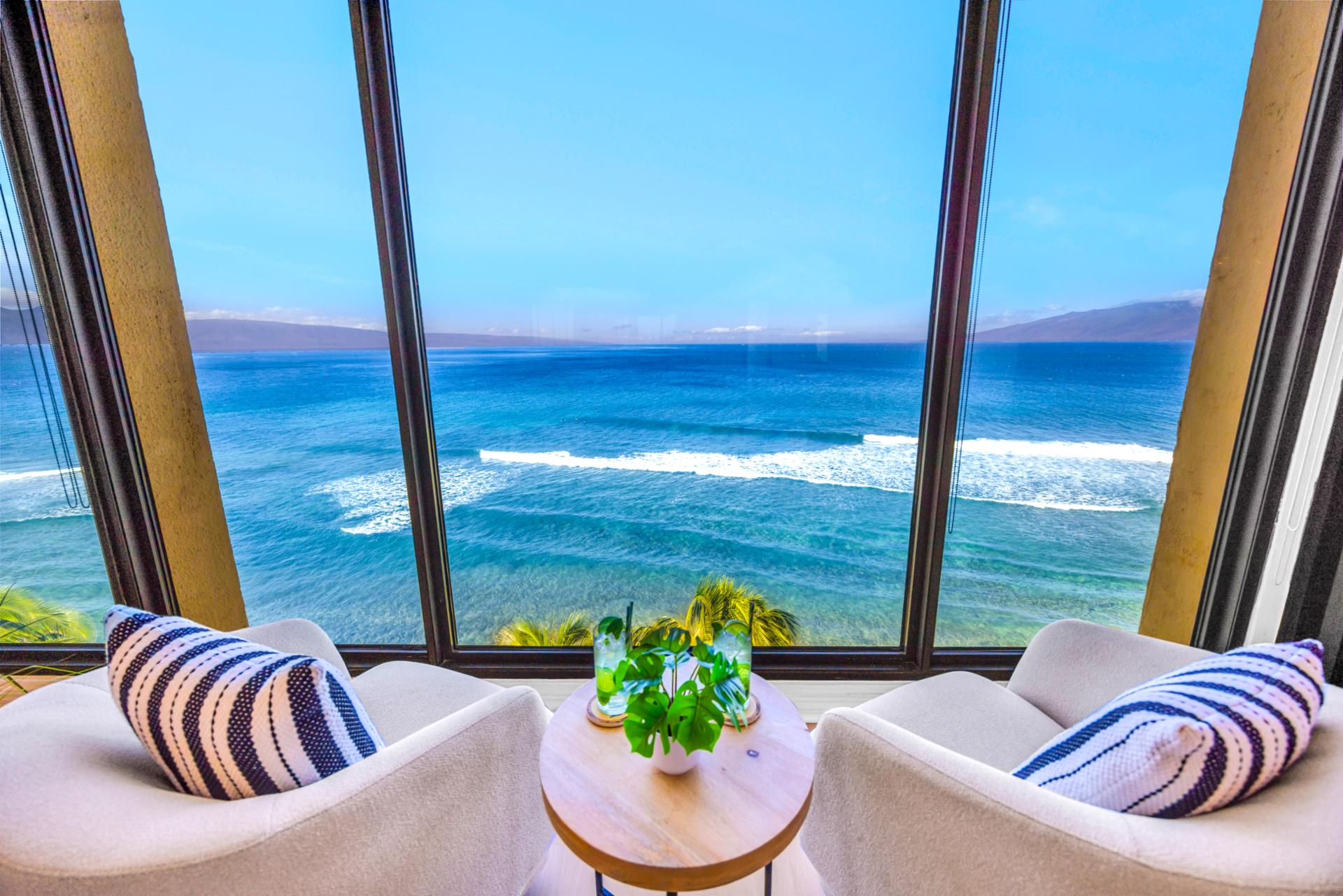 Two lounge chairs by the window invite slow afternoons, with Molokai on the horizon beyond the blue water.