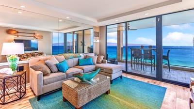 Curl up in a sandy-hued sectional while the sea serenades you through glass panels wide as a horizon hug