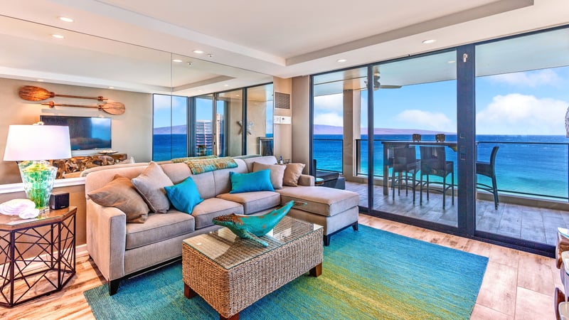 Curl up in a sandy-hued sectional while the sea serenades you through glass panels wide as a horizon hug