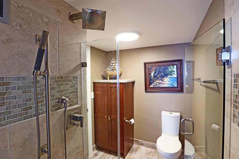 A glistening shower wrapped in glass and mosaic stone, where each rinse feels like a seaside retreat for the soul