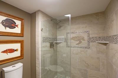 Step into an undersea dream, where playful fish art and ocean-stone tiles turn every rinse into a seaside escape