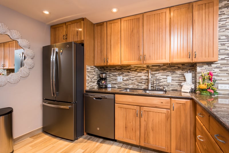 Honeyed cabinetry glows under recessed light, as if the wood itself remembers every laughter-filled recipe passed down