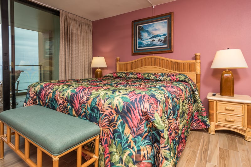 Pink walls, palm prints, and a balcony peek at the tropics—this room is a joyful burst of warmth and whimsy