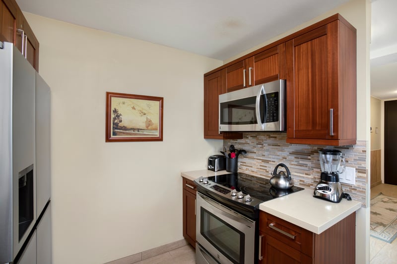 The kitchen unfolds with artisanal warmth, where polished cabinetry and ocean vistas craft a seamless symphony of form and function MAH-611