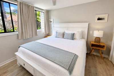 Sink into the king bed dressed in crisp white linens and soft blue accents, with a cooling ceiling fan overhead and two garden-view windows dressed in flowing drapes -- Maui's tropical greenery your first sight each morning.