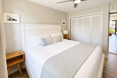The bedroom's louvered closet doors and easy flow toward the living area and lanai beyond make it simple to step from a restful night's sleep straight into island living.