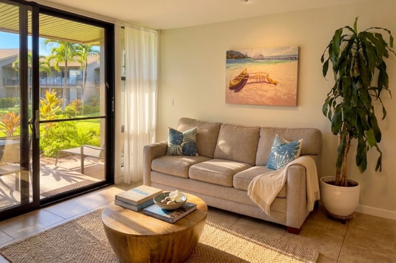 The living room's sliding glass door opens straight onto your private lanai and Mahina Surf's tropical grounds, blending indoor comfort with island living.