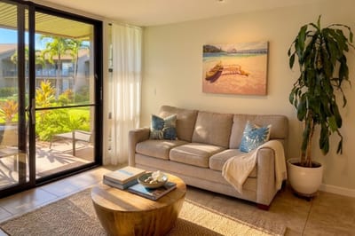 The living room's sliding glass door opens straight onto your private lanai and Mahina Surf's tropical grounds, blending indoor comfort with island living.