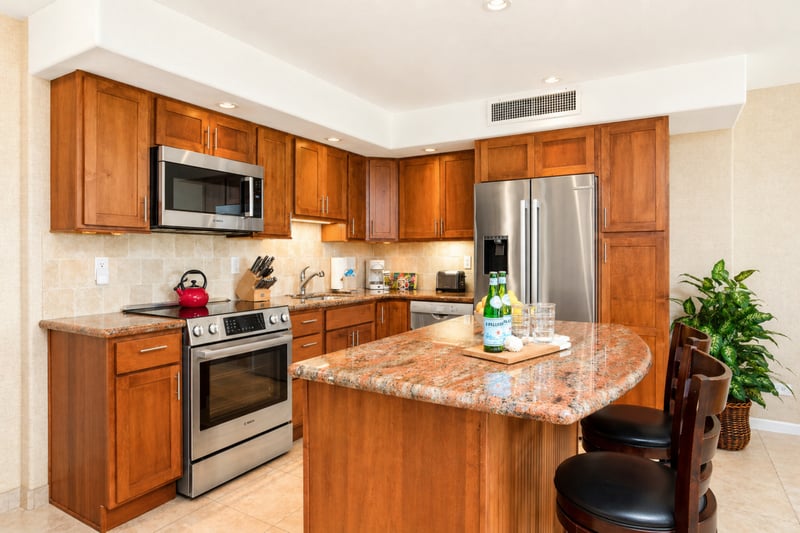 Fully equipped kitchen at Maui Eldorado H207 — stainless range, microwave, and French-door refrigerator with granite countertops