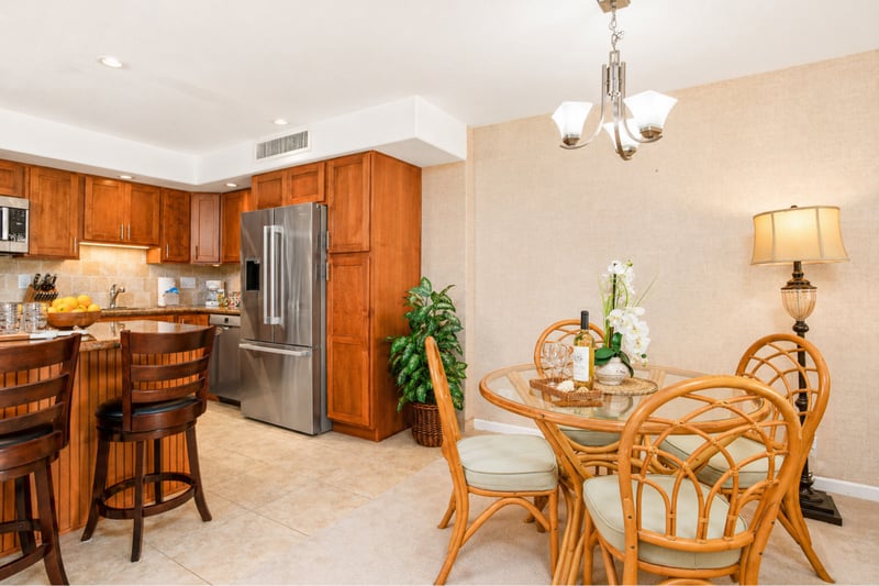 Dining nook at Maui Eldorado H207 — glass-top rattan table for four beside the kitchen