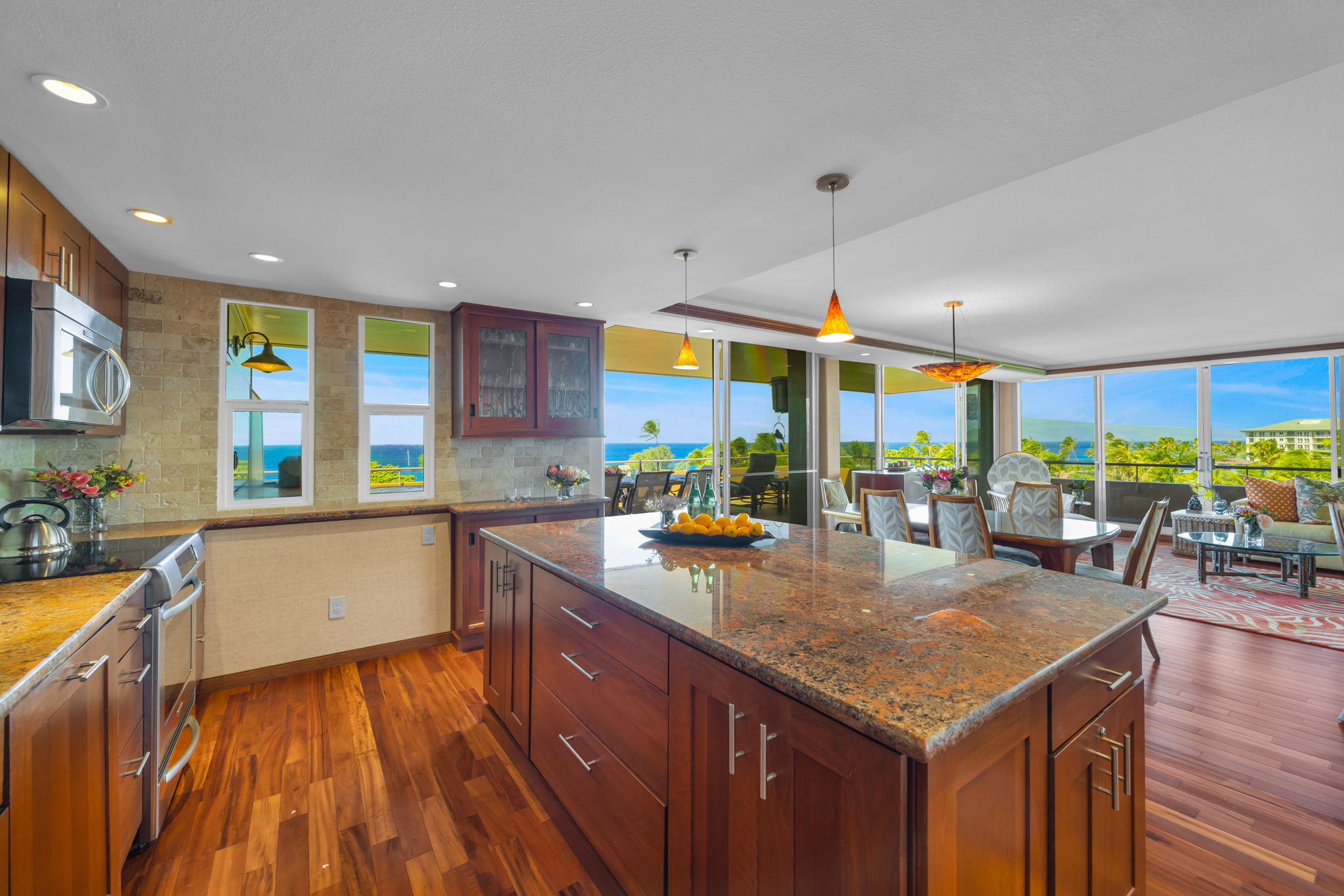 A wall of windows fills the kitchen and dining space with natural light and ocean views.