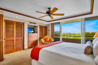 Cozy reading corner and ceiling fan complete this restful primary retreat.