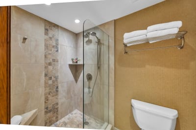 Guest bath with walk-in shower and tiled finishes offers both style and convenience.