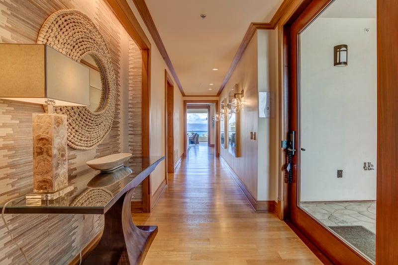 Step through the door into a hallway of warmth and light—where coastal textures, modern art, and ocean views await