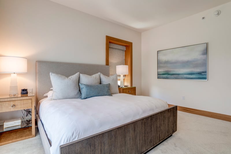 A plush king bed framed in weathered wood anchors the space with a balance of strength, calm, and quiet luxury