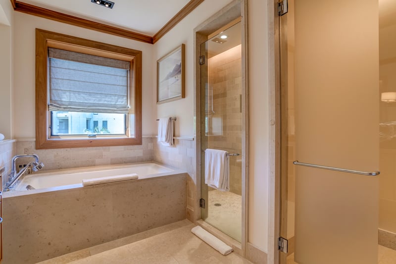This tub is a throne of tranquility, nestled beneath a sunlit window and ready to host your most royal soak