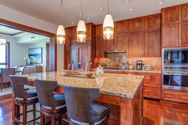 A kitchen where granite glistens like island treasure and the cabinets look carved by tiki gods with great taste    