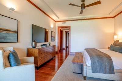 A plush bed crowned with tailored pillows offers rest wrapped in refinement and whispers of ocean breeze