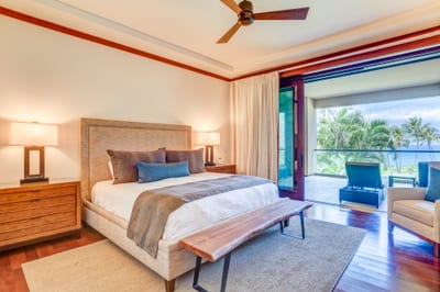 This master retreat blends warm wood tones with soft neutrals, creating a sanctuary of coastal sophistication