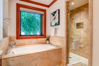 Bathed in natural light and framed by warm wood, this spa-like tub offers a front-row seat to tranquility
