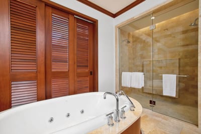 A shower so sleek, even the water flows in hushed admiration—wrapped in golden stone and glassy grace