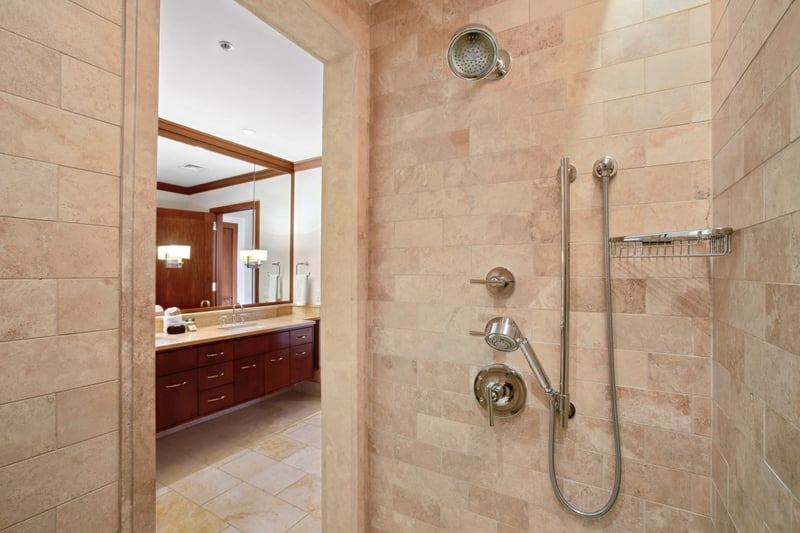 This shower whispers “serenity now” with stone walls so warm, even your shampoo bottle might start to meditate