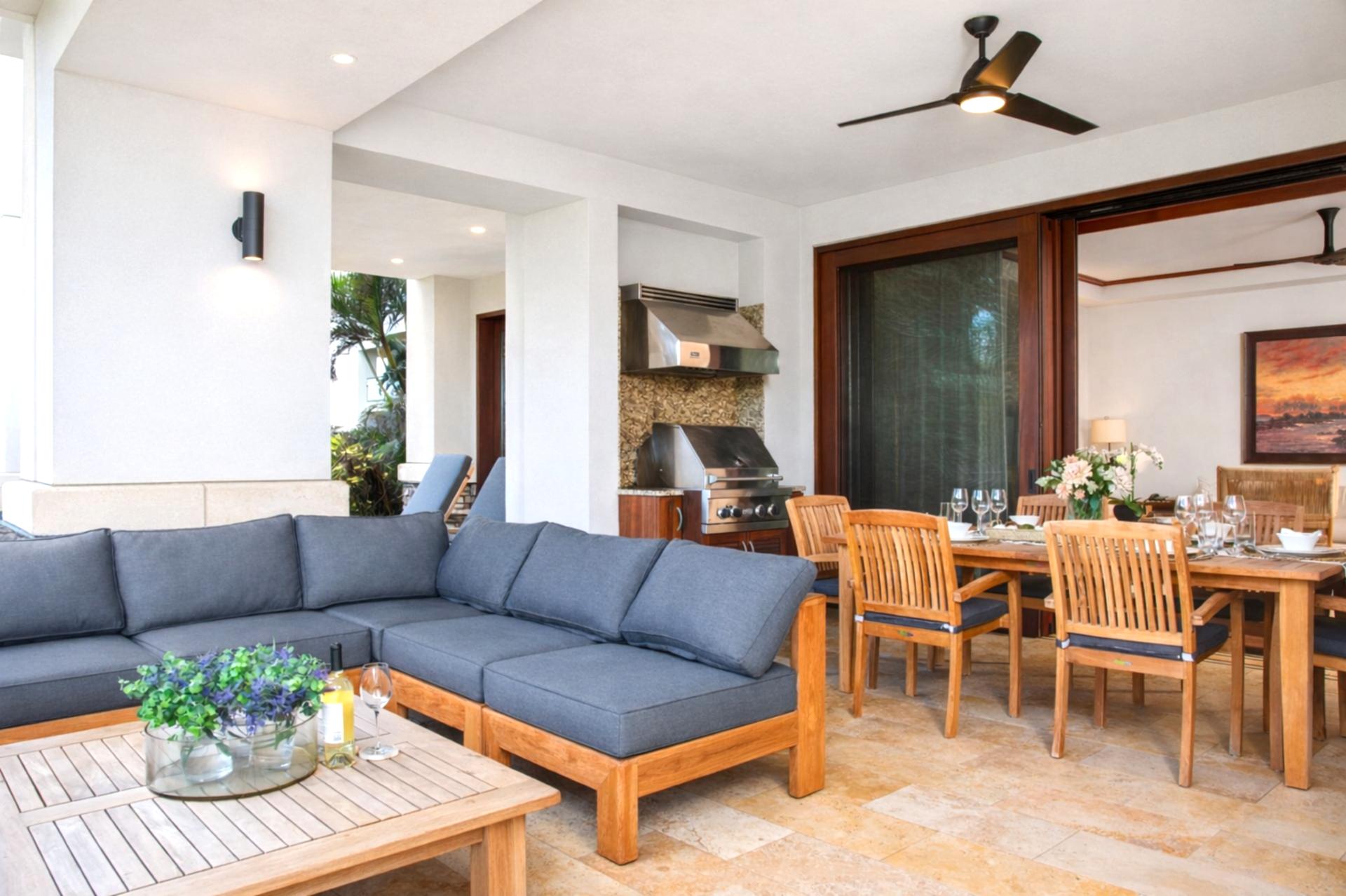 A spacious sectional and wood beam ceilings anchor your living area, flowing seamlessly to the lanai through wide sliding glass doors.