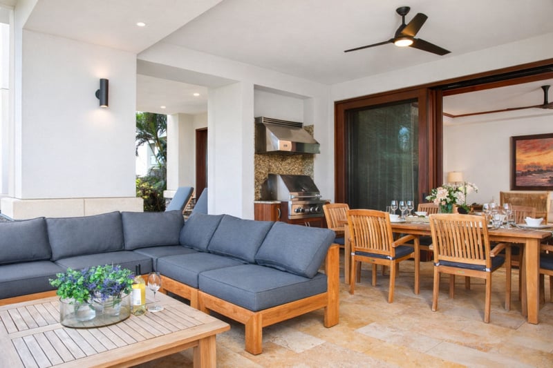 A spacious sectional and wood beam ceilings anchor your living area, flowing seamlessly to the lanai through wide sliding glass doors. MON-2204