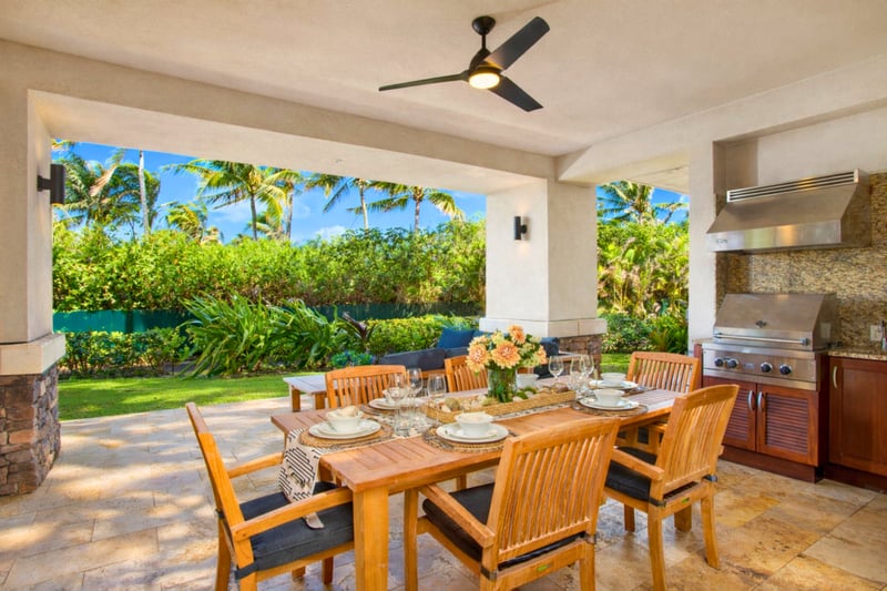 Dine al fresco at your covered lanai table, where ocean views and tropical landscaping create a memorable evening setting. MON-2204