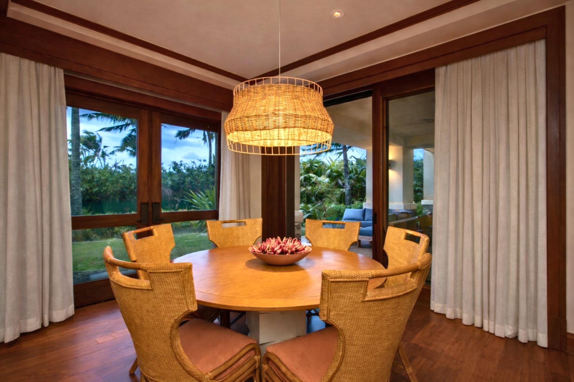 A round wood dining table sits beneath a statement chandelier, creating an inviting space for shared meals and conversation.
