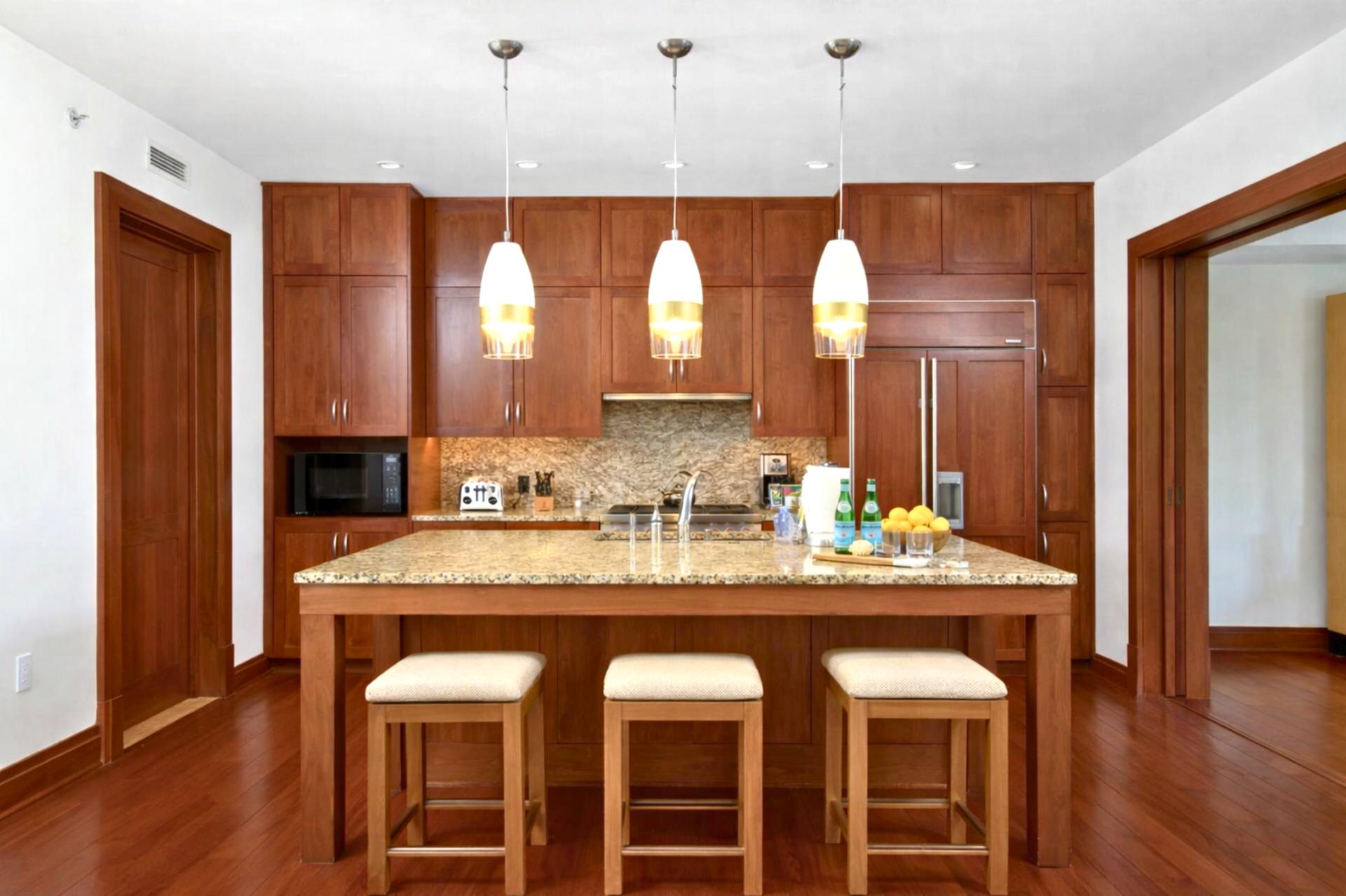 Pendant lighting highlights your expansive kitchen island, with barstools perfectly positioned for coffee or casual meals.