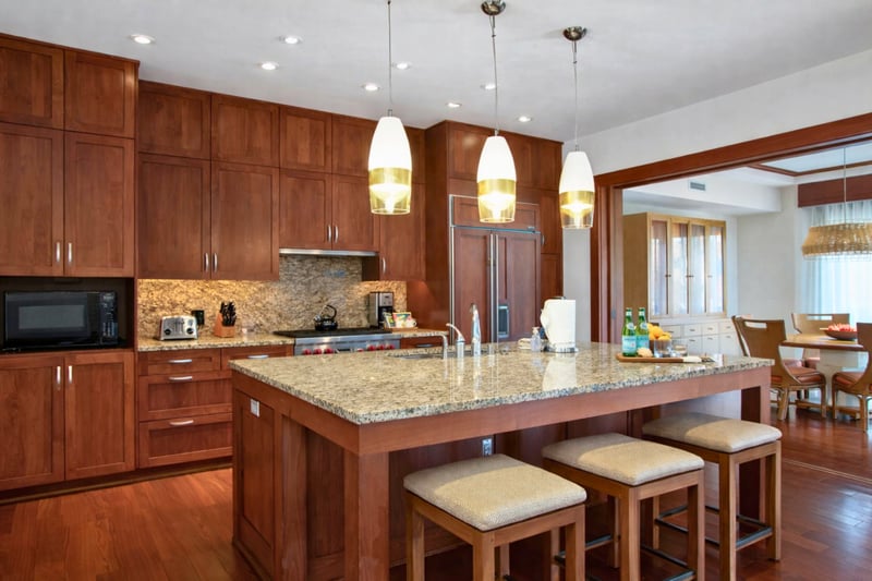 Rich wood cabinetry and granite counters define your kitchen, complete with bar seating for four and generous prep space. MON-2204