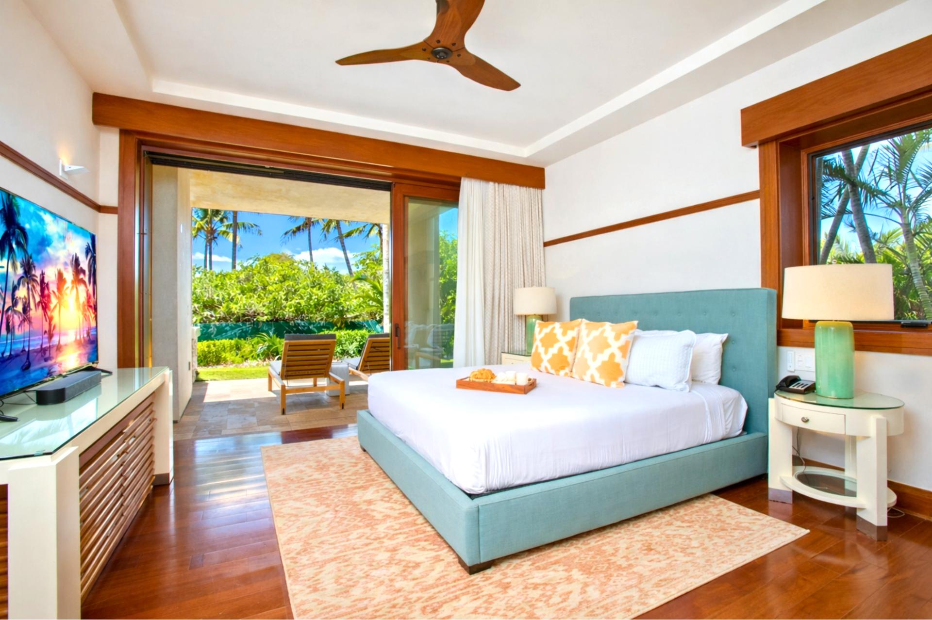 Your primary bedroom features a King bed, mounted TV, and sliding doors that open directly to tropical views.