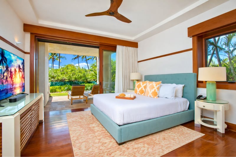 Your primary bedroom features a King bed, mounted TV, and sliding doors that open directly to tropical views. MON-2204