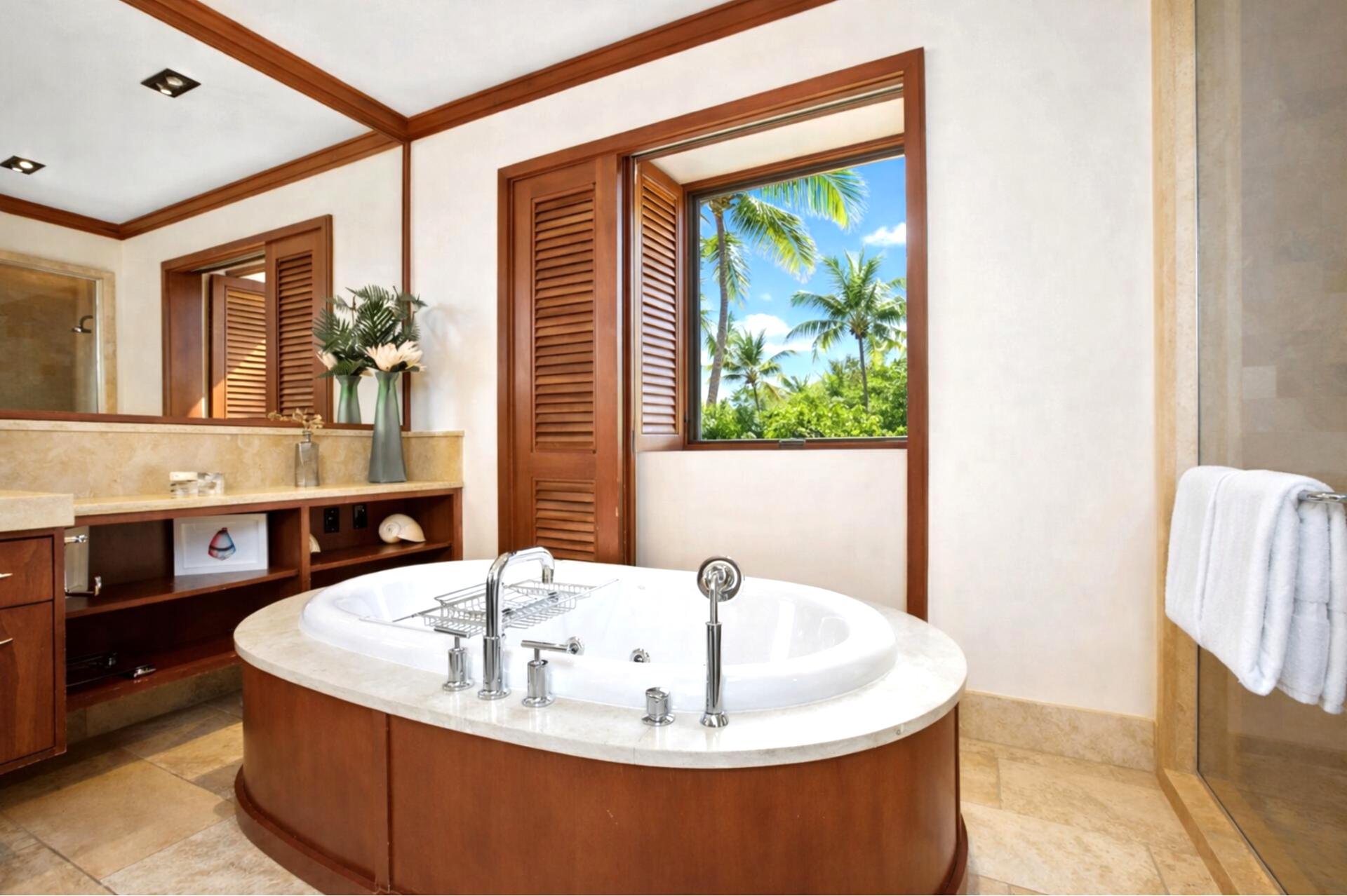 A large soaking tub sits beneath bright lighting and rich wood trim, offering a peaceful end to beach days.