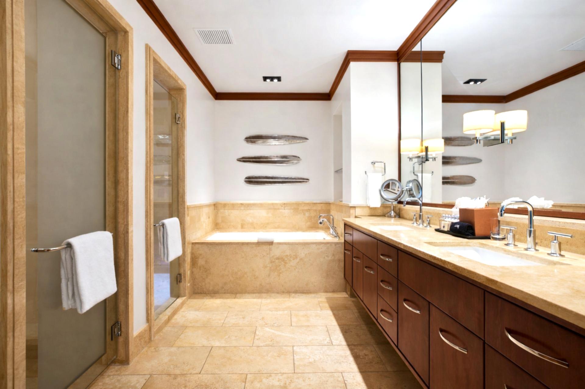 Soft neutral tones and tropical views create a restful guest retreat with easy access to the nearby bath.