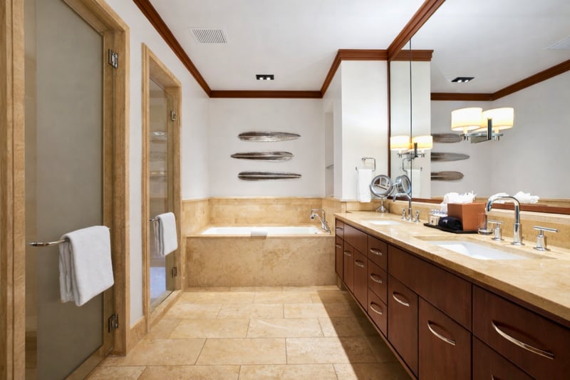Soft neutral tones and tropical views create a restful guest retreat with easy access to the nearby bath.