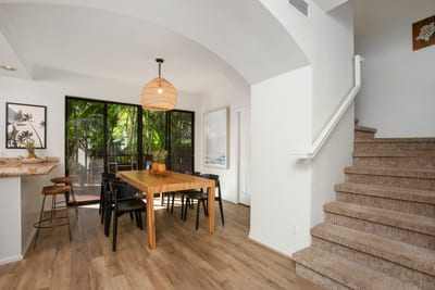 Experience stylish island dining with woven textures, black-accent chairs, and a gorgeous view of the green canopy