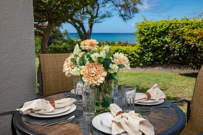 Dine steps from the sea where garden blooms and ocean views meet—your alfresco table is set for paradise NAP-A25
