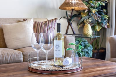 Sip, settle, and stay a while—this cozy island nook offers wine-ready charm and golden coastal textures throughout NAP-A25