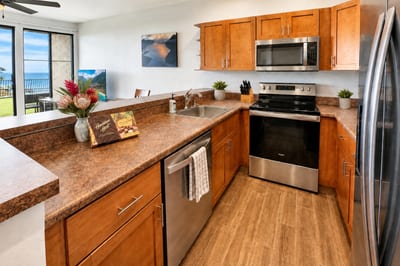 Fully equipped kitchen at Napili Point B31 — stainless appliances and ocean views from the sink, with a welcome treat of Hawaiian Host chocolates